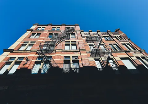 Montreal brick apartment buildings with exterior staircases against a clear sky