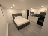 Open studio sleeping area beside the kitchenette — Cozy Studio Near YUL