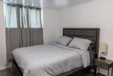Bedroom with bed and bedside lighting — Rehoboth 1BR in Laval