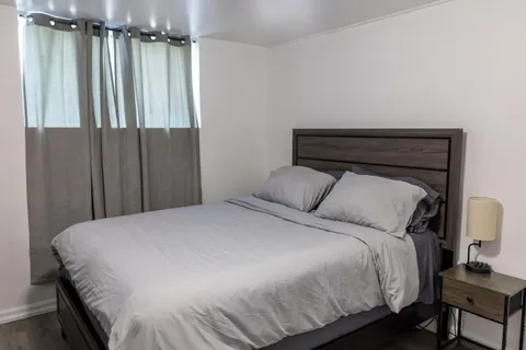 Bedroom with bed and bedside lighting — Rehoboth 1BR in Laval
