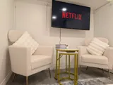 TV seating area with armchairs — Stylish Modern 1BR with EV Charger