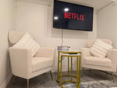 TV seating area with armchairs — Stylish Modern 1BR with EV Charger